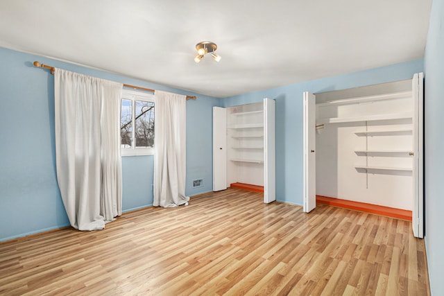 4819 Thorntree Dr, West Bloomfield, MI 48322 - unfurnished bedroom featuring light wood-style flooring, multiple closets, and baseboards