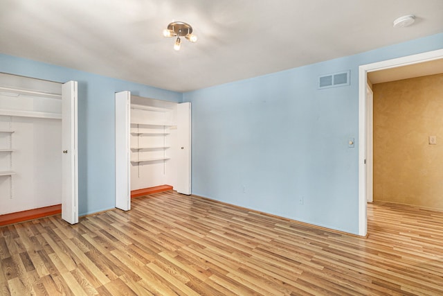 4819 Thorntree Dr, West Bloomfield, MI 48322 - unfurnished bedroom featuring light wood-type flooring and multiple closets