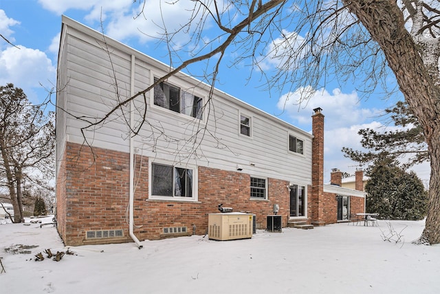 4819 Thorntree Dr, West Bloomfield, MI 48322 - snow covered back of property with brick siding, a chimney, central AC, and entry steps