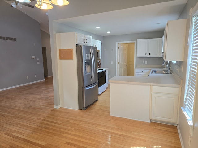 kitchen featuring stainless steel fridge, a sink, electric stove, light wood-style flooring, and recessed lighting