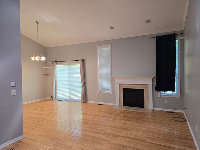 unfurnished living room with crown molding, a chandelier, light wood-type flooring, a fireplace with flush hearth, and baseboards