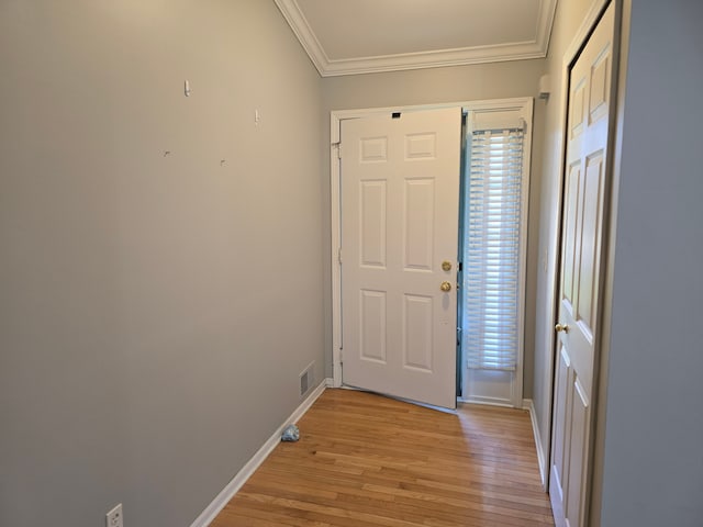 foyer with ornamental molding, light wood finished floors, and baseboards