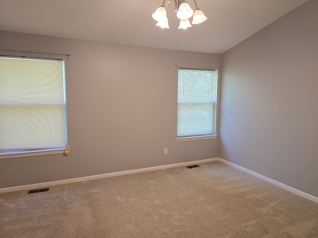 unfurnished room featuring a chandelier, carpet floors, and baseboards