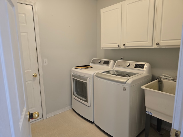 laundry room featuring washer and dryer, cabinet space, light flooring, and baseboards