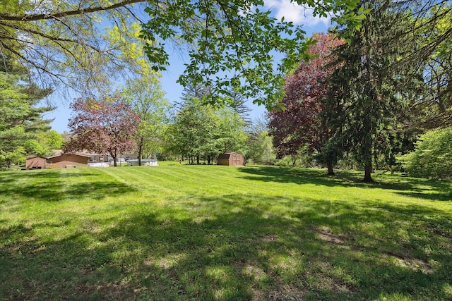 7317 Bircklan Dr, Canton, MI 48187 - view of green lawn with a storage unit and an outbuilding