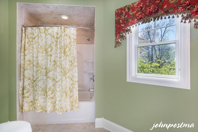 bathroom featuring plenty of natural light, shower / tub combo, toilet, and baseboards