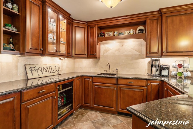 kitchen with open shelves, a sink, beverage cooler, dark stone counters, and backsplash