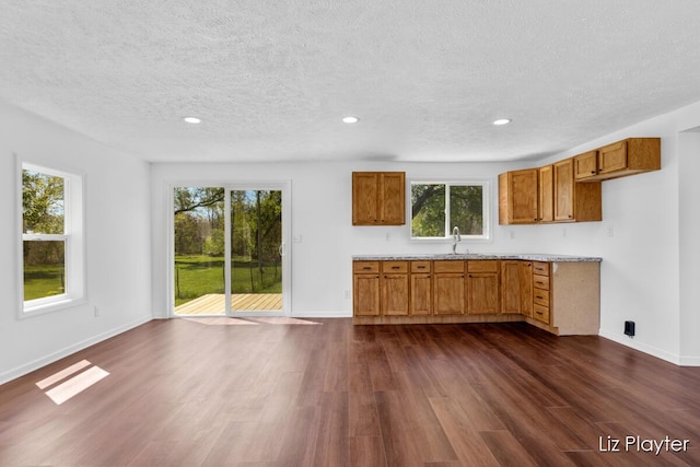 311 W Fenwick Rd, Fenwick, MI 48834 - kitchen featuring a textured ceiling, brown cabinets, dark wood finished floors, recessed lighting, and baseboards