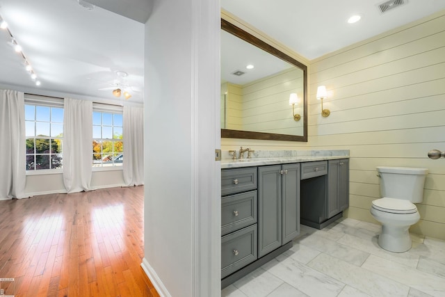 141 Paton Way, Romeo, MI 48065 - bathroom featuring vanity, a ceiling fan, toilet, baseboards, and wood walls