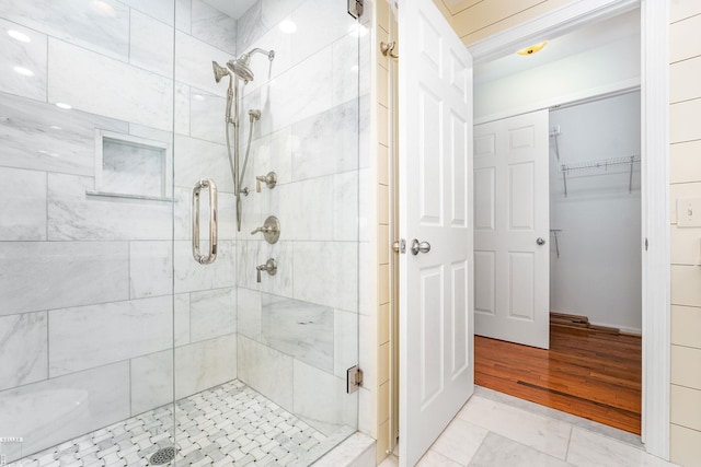141 Paton Way, Romeo, MI 48065 - bathroom with a stall shower, a walk in closet, and wood finished floors