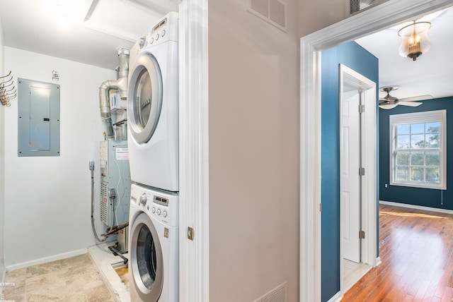 141 Paton Way, Romeo, MI 48065 - laundry room with stacked washing machine and dryer, electric panel, a ceiling fan, and baseboards