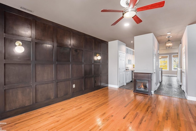 141 Paton Way, Romeo, MI 48065 - unfurnished living room with hardwood / wood-style floors, ceiling fan, and baseboards