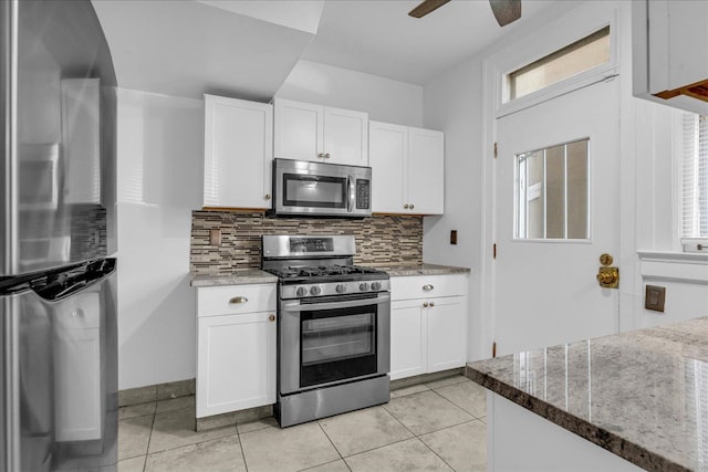 kitchen with stainless steel appliances, tasteful backsplash, white cabinetry, and light tile patterned flooring