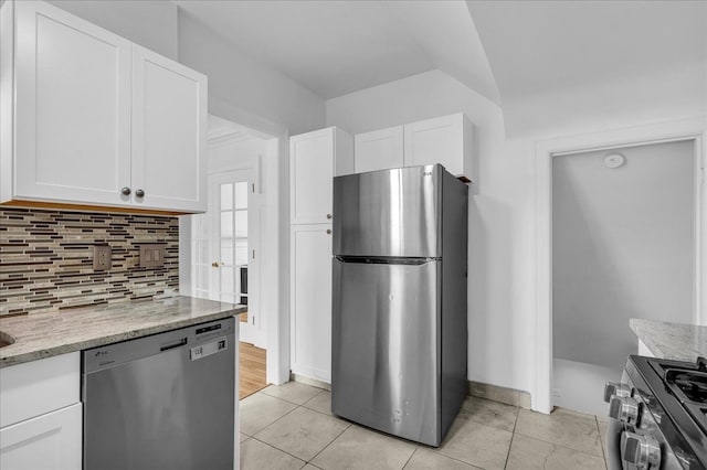 kitchen featuring appliances with stainless steel finishes, tasteful backsplash, white cabinets, and light stone countertops