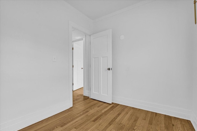 unfurnished room with light wood-type flooring and baseboards
