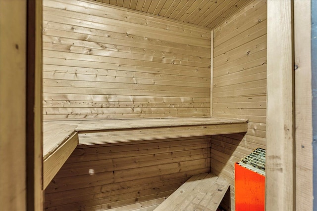 sauna / steam room with wooden ceiling and wood walls