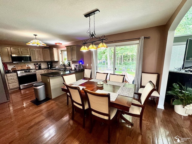 dining area featuring dark wood-style floors and a textured ceiling