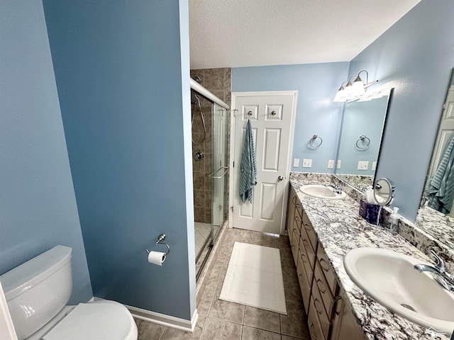 full bathroom featuring toilet, a stall shower, double vanity, tile patterned flooring, and a textured ceiling