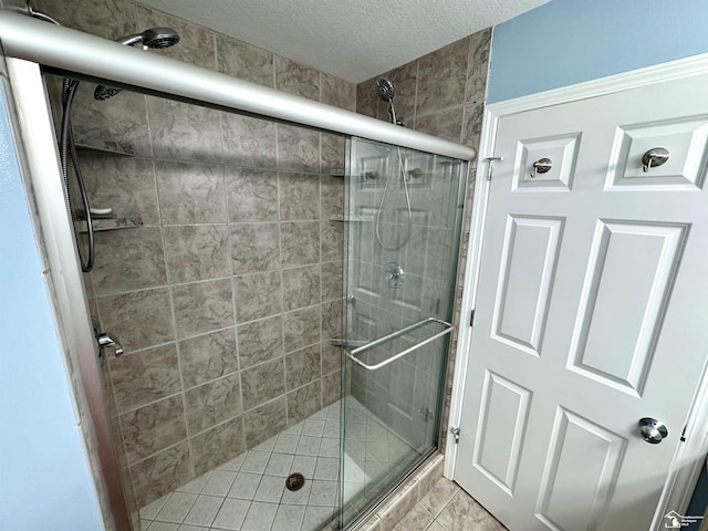 bathroom with a stall shower and a textured ceiling