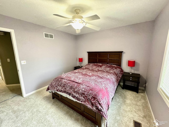 bedroom with carpet flooring, baseboards, ceiling fan, and a textured ceiling