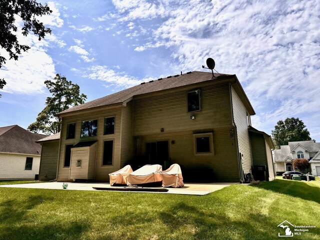 back of property featuring a patio area and a lawn