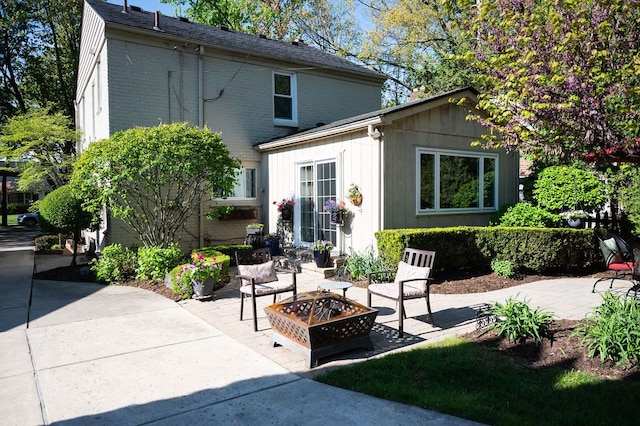 rear view of property with an outdoor fire pit and a patio area