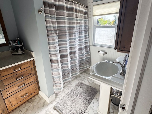 bathroom with a sink, a shower with shower curtain, and tile patterned flooring