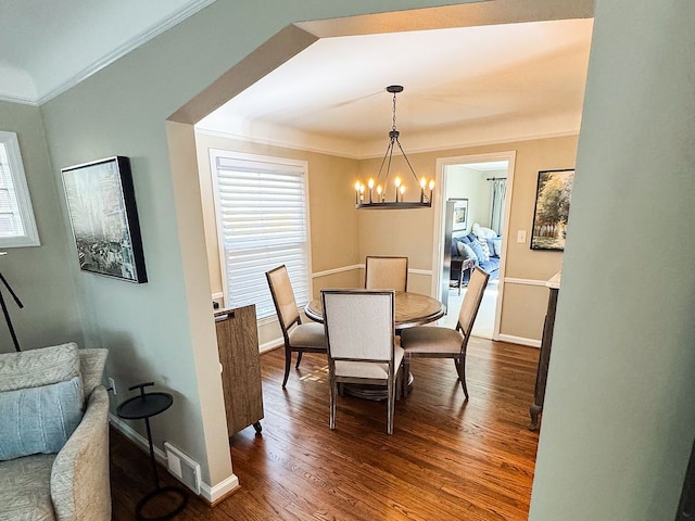 dining area with a chandelier, crown molding, dark wood-style floors, and baseboards
