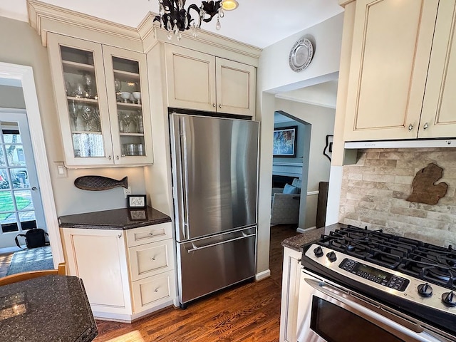 kitchen featuring appliances with stainless steel finishes, cream cabinets, dark wood-style floors, and backsplash