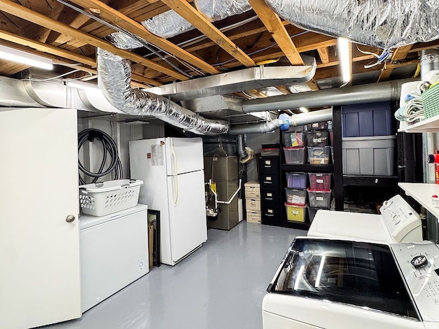 unfinished below grade area with freestanding refrigerator, independent washer and dryer, and heating unit