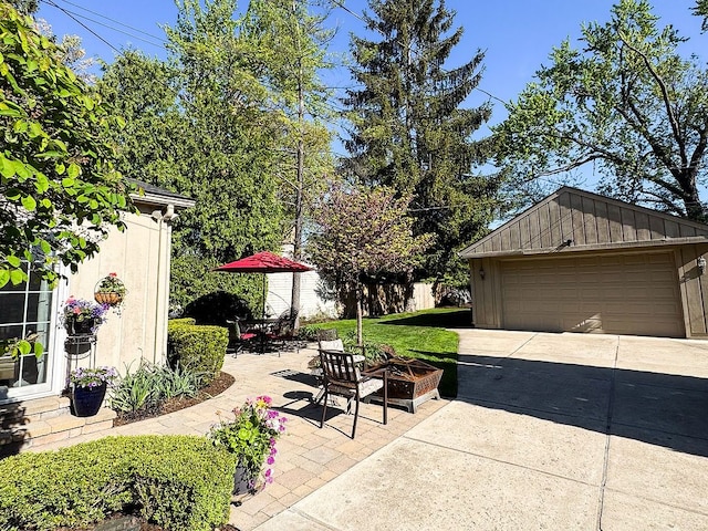 view of patio with an outbuilding and a detached garage