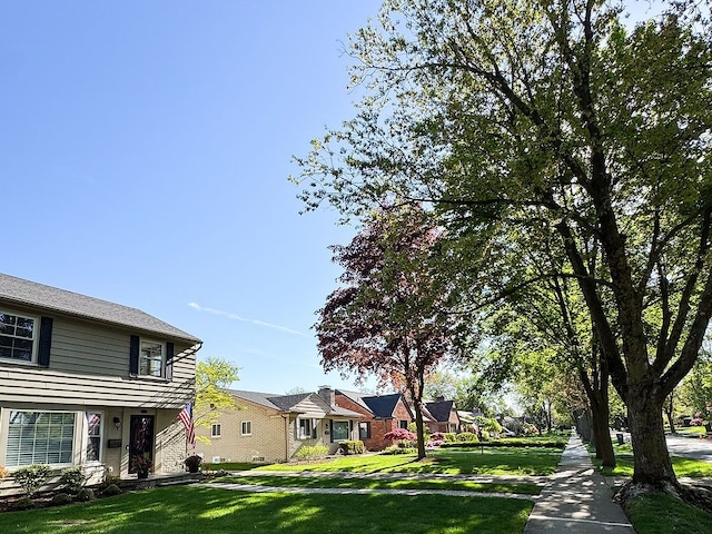 view of green lawn with a residential view