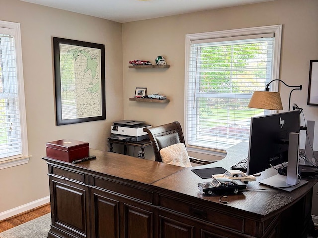 home office with baseboards and wood finished floors