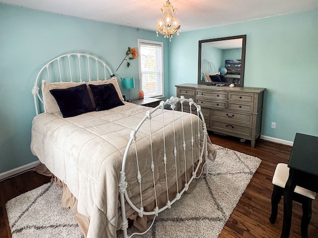 bedroom featuring baseboards, wood finished floors, and a chandelier