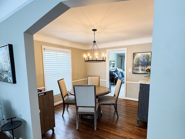 dining space with a chandelier, dark wood-style floors, baseboards, and ornamental molding