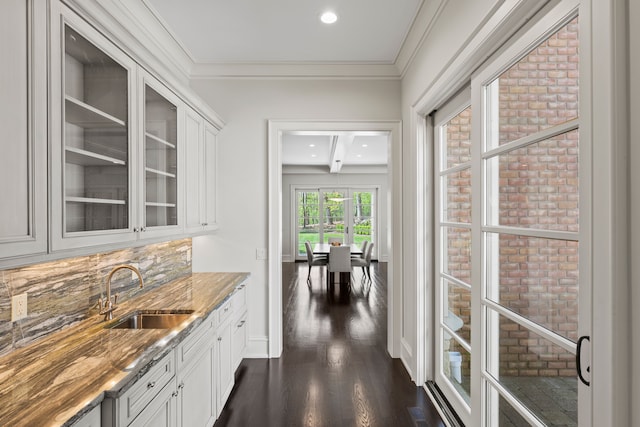 indoor wet bar with dark wood finished floors, ornamental molding, recessed lighting, and baseboards