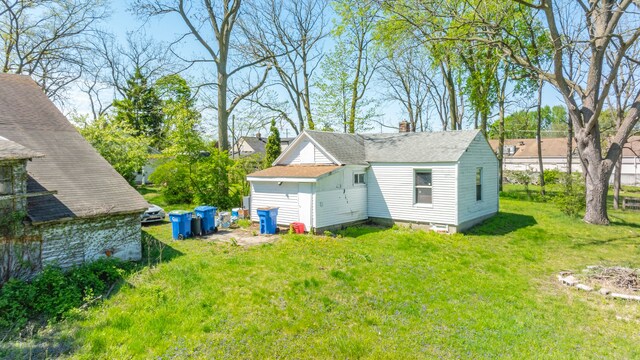 4201 Chicago Rd, Warren, MI 48092 - back of property with a yard, a chimney, and roof with shingles