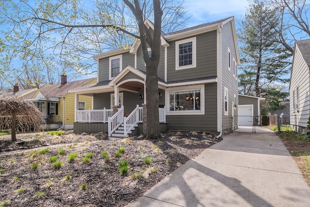 view of front of property featuring a porch, a garage, fence, and a gate