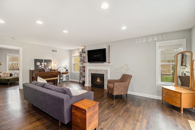 living room with plenty of natural light, a tile fireplace, recessed lighting, dark wood finished floors, and baseboards