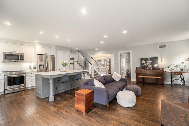 living area with stairway, dark wood-type flooring, recessed lighting, and baseboards