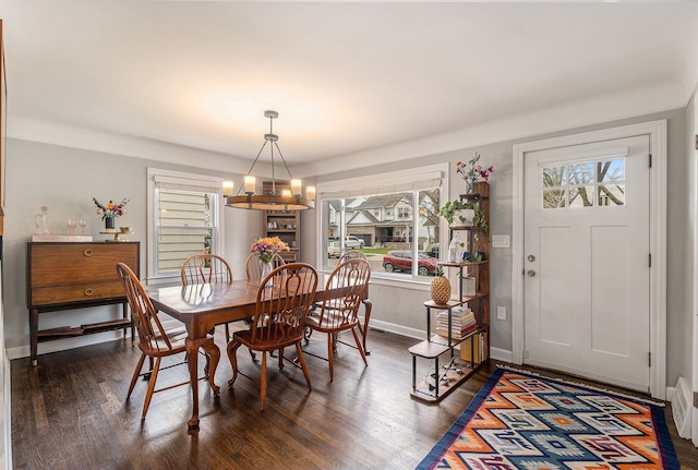 dining area with a chandelier and dark wood finished floors