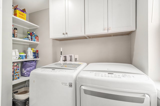 clothes washing area featuring independent washer and dryer and cabinet space