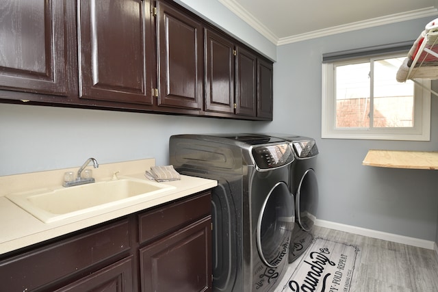 18516 Ranier Dr, Macomb, MI 48042 - laundry room with cabinet space, washer and dryer, crown molding, baseboards, and light wood-style flooring