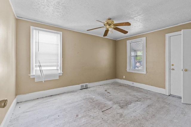 unfurnished room with a ceiling fan, a textured ceiling, baseboards, wood finished floors, and crown molding