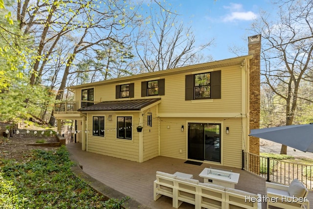 401 Stickney Ridge Rd, Grand Haven, MI 49417 - back of property featuring a chimney, a standing seam roof, a metal roof, a balcony, and a patio area