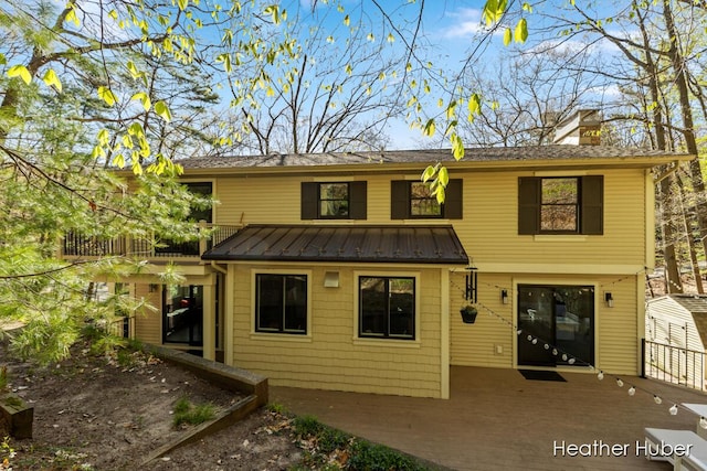401 Stickney Ridge Rd, Grand Haven, MI 49417 - back of property featuring a standing seam roof, a metal roof, and a chimney