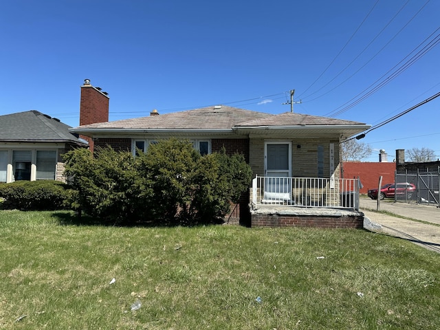 17124 Pinehurst St, Detroit, MI 48221 - view of front of house featuring a front lawn, a porch, a chimney, and brick siding