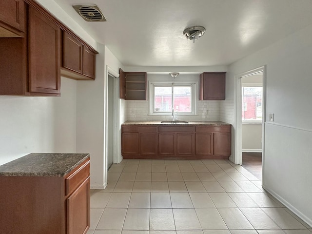 17124 Pinehurst St, Detroit, MI 48221 - kitchen featuring a sink, backsplash, baseboards, light tile patterned flooring, and open shelves