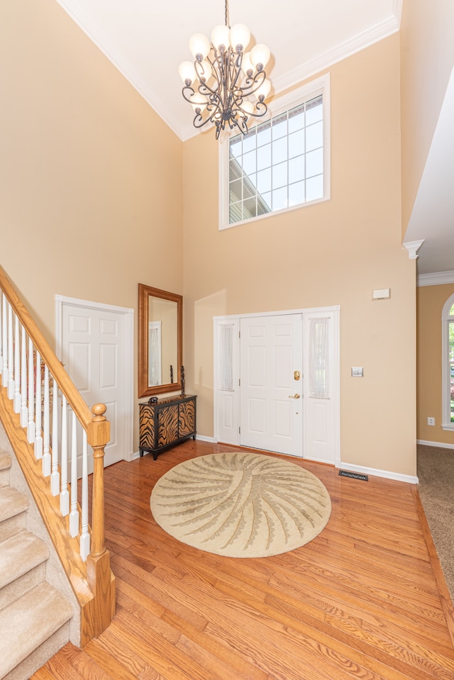 1090 Shetland Dr, South Lyon, MI 48178 - entrance foyer with a chandelier, ornamental molding, baseboards, wood finished floors, and a high ceiling