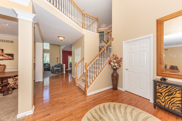 1090 Shetland Dr, South Lyon, MI 48178 - entrance foyer with stairs, light wood-style floors, baseboards, a high ceiling, and ornamental molding